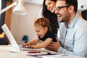 mom and dad with child playing on laptop